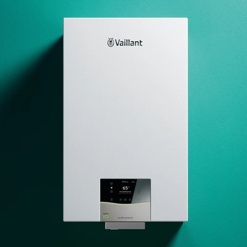 A white Vaillant ecoTEC exclusive boiler with a digital display showing 65°C on a teal wall.
