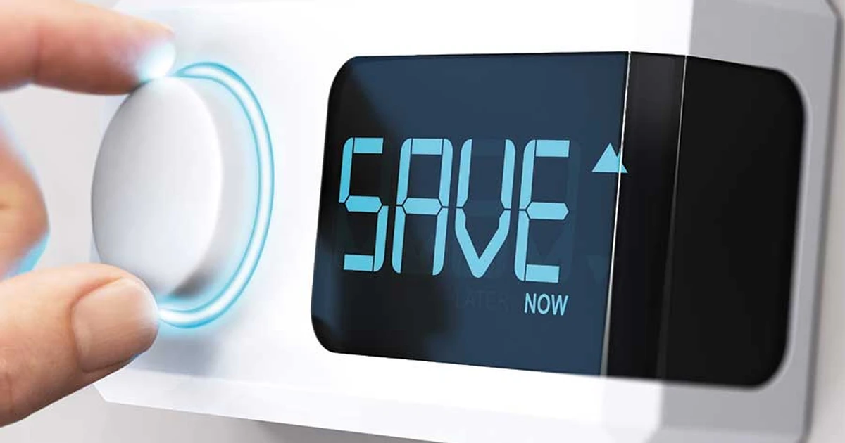 Person's finger adjusts a glowing white smart thermostat dial, with a digital screen showing 'SAVE' and 'NOW'.